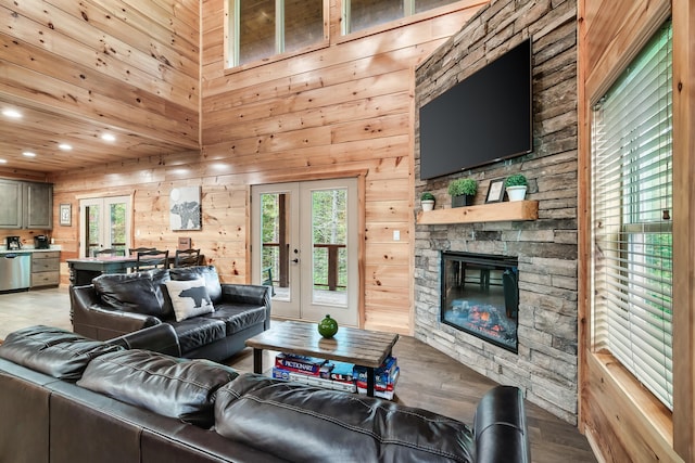 living room featuring wooden walls, hardwood / wood-style floors, a healthy amount of sunlight, and french doors