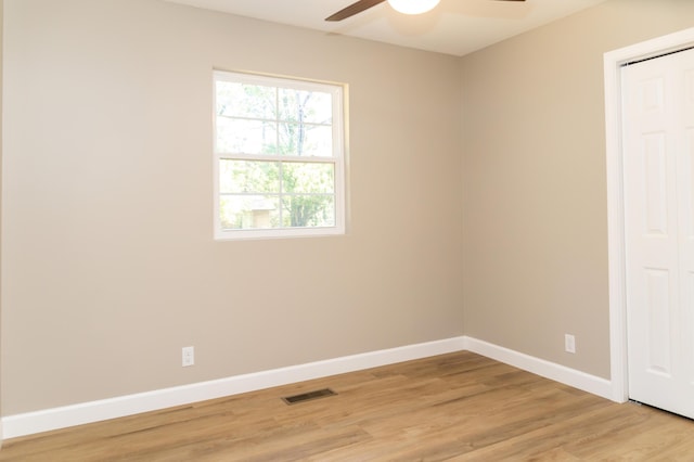 empty room with ceiling fan and light hardwood / wood-style flooring