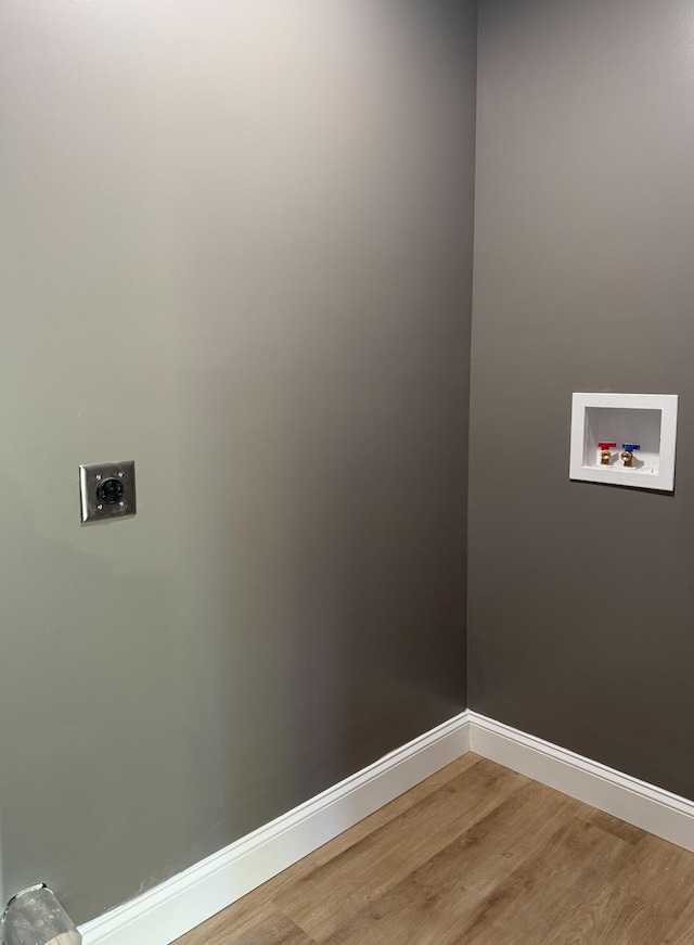 clothes washing area with electric dryer hookup, washer hookup, and wood-type flooring