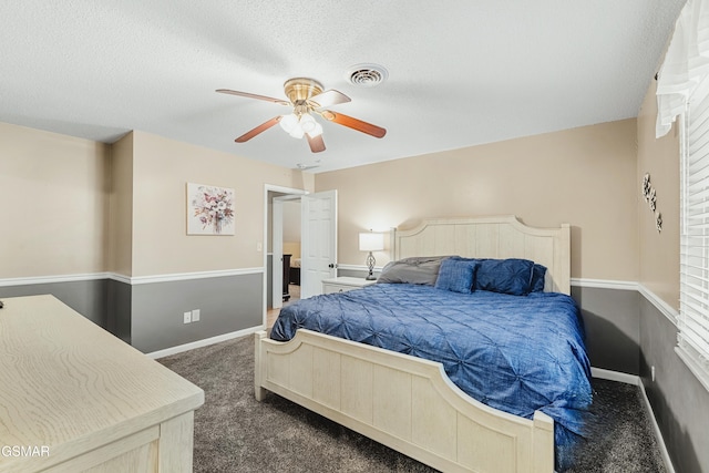 carpeted bedroom featuring a textured ceiling and ceiling fan