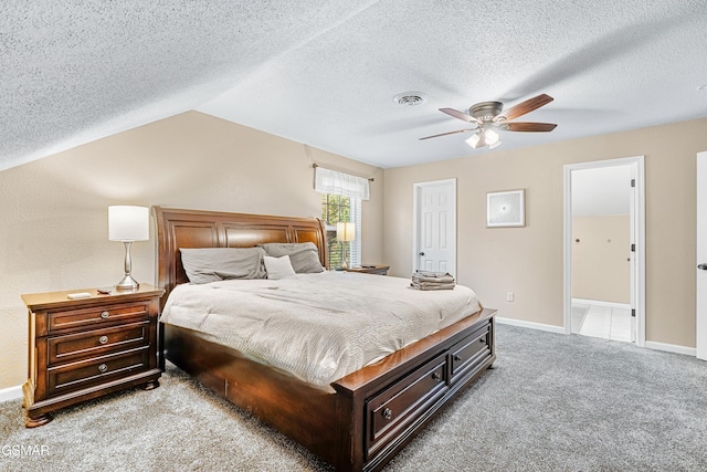 carpeted bedroom featuring a textured ceiling, vaulted ceiling, and ceiling fan