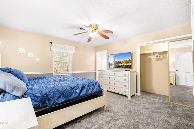 carpeted bedroom featuring ceiling fan, a closet, and a textured ceiling