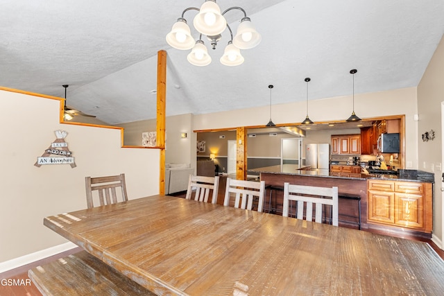 dining area featuring lofted ceiling, dark hardwood / wood-style floors, an inviting chandelier, and a textured ceiling