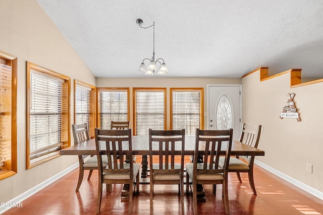 dining space featuring an inviting chandelier, a healthy amount of sunlight, and wood-type flooring