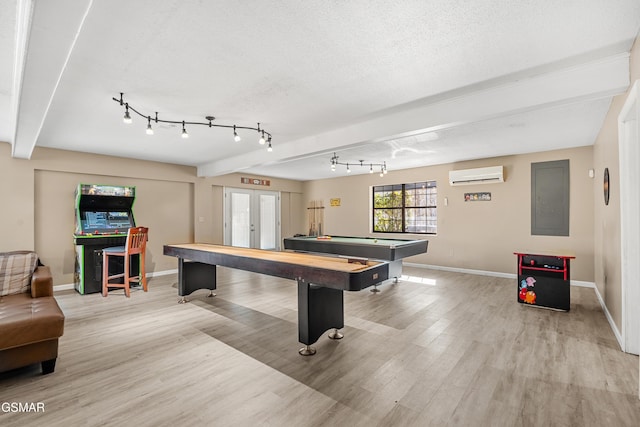 game room featuring french doors, a textured ceiling, light hardwood / wood-style flooring, electric panel, and a wall unit AC