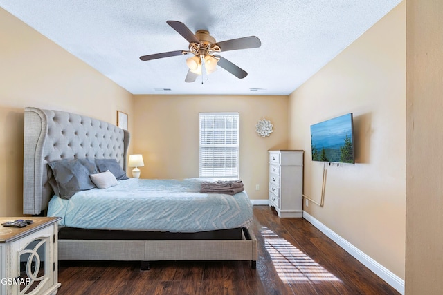 bedroom with ceiling fan, dark hardwood / wood-style floors, and a textured ceiling