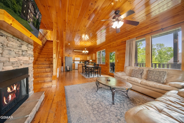 368 Oak Lake Dr, Sevierville, TN 37876 - living area with wooden walls, light wood-style floors, wood ceiling, ceiling fan, and a stone fireplace