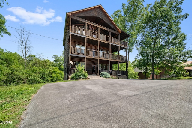 368 Oak Lake Dr, Sevierville, TN 37876 - view of front of home featuring driveway, log veneer siding, and a balcony