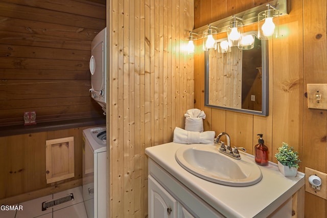 bathroom with tile patterned floors, wood walls, and vanity