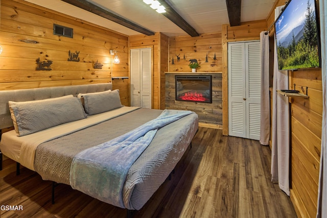 bedroom featuring beamed ceiling, dark hardwood / wood-style flooring, and wood walls