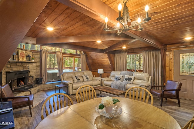 dining room featuring beam ceiling, an inviting chandelier, wooden walls, a fireplace, and wood ceiling