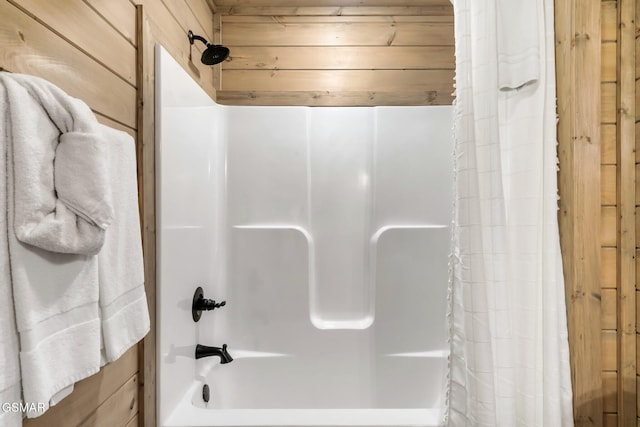 bathroom with shower / bath combo, wooden walls, and wooden ceiling