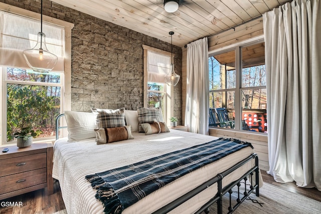 bedroom with dark hardwood / wood-style floors, multiple windows, and wood ceiling