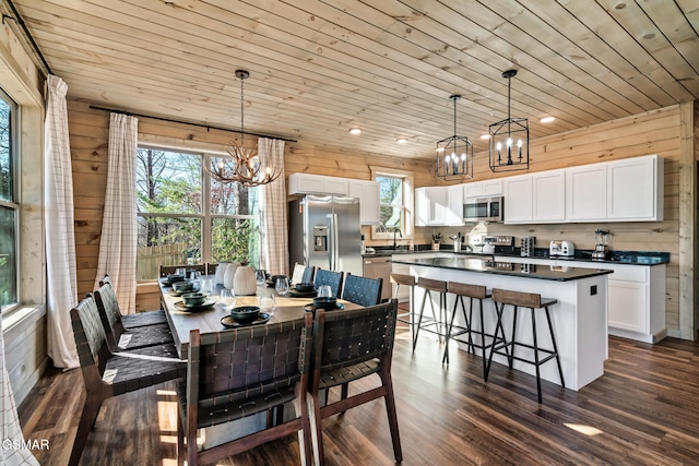 dining space featuring wooden walls, plenty of natural light, wooden ceiling, and dark hardwood / wood-style floors