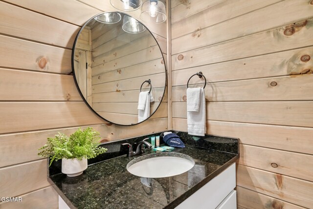 bathroom featuring wood walls and vanity