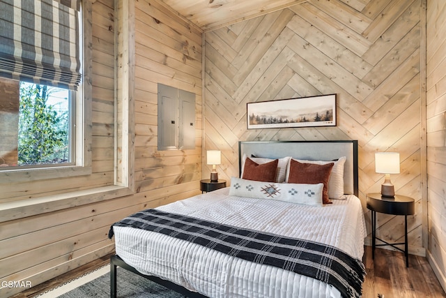 bedroom with hardwood / wood-style floors, electric panel, and wooden walls