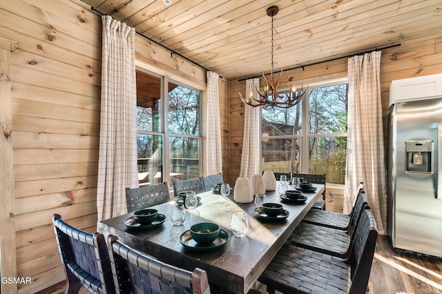 dining room with wood walls, dark wood-type flooring, wood ceiling, and a notable chandelier