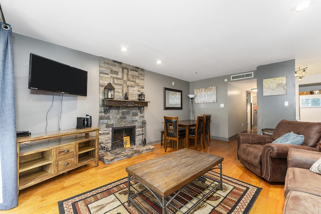 living room with light wood-type flooring and a fireplace