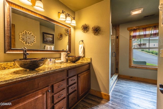 1128 Anastasia Way, Gatlinburg, TN 37738 - bathroom featuring wood finished floors, double vanity, baseboards, and a shower stall