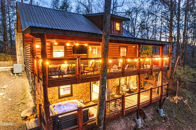 3115 E E Pkwy, Gatlinburg, TN 37738 - back of property featuring metal roof, a balcony, central air condition unit, an outdoor hot tub, and stone siding