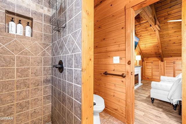 3115 E E Pkwy, Gatlinburg, TN 37738 - bathroom featuring toilet, a glass covered fireplace, wood finished floors, tiled shower, and beamed ceiling