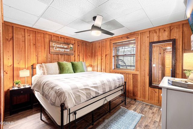 3115 E E Pkwy, Gatlinburg, TN 37738 - bedroom featuring a paneled ceiling, ceiling fan, wooden walls, and wood finished floors