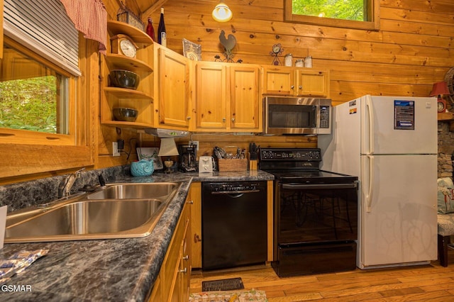 kitchen with sink, light hardwood / wood-style floors, lofted ceiling, wooden walls, and black appliances