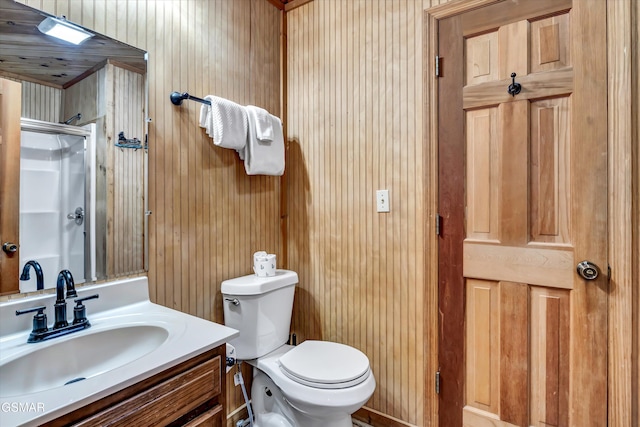 bathroom featuring vanity, toilet, and a shower with door