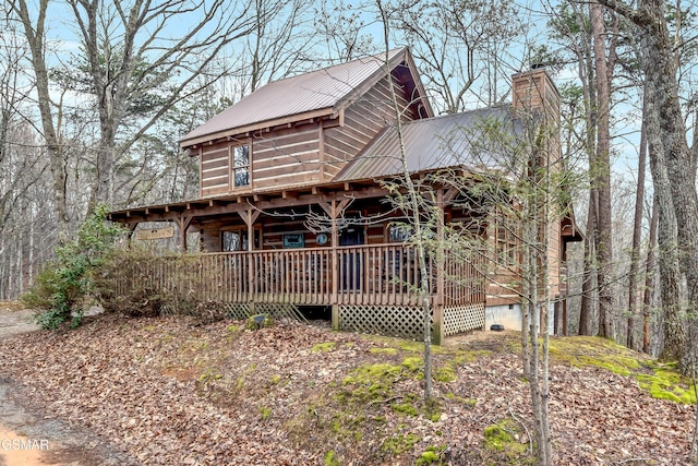 view of front of property featuring crawl space, metal roof, and a chimney