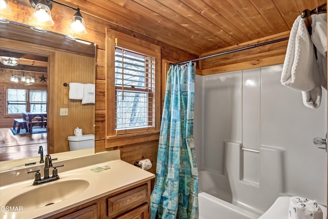 full bath featuring toilet, wood ceiling, shower / bathtub combination with curtain, vanity, and wood walls