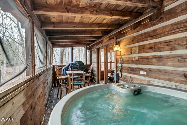 unfurnished sunroom featuring wooden ceiling, a hot tub, and beamed ceiling