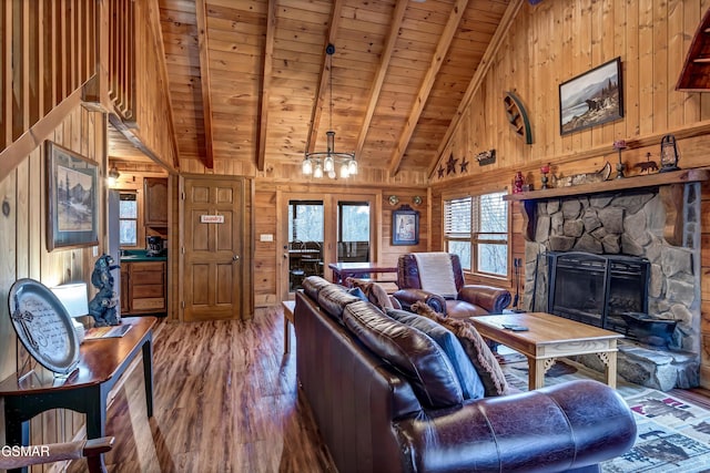 living area featuring a wealth of natural light, wood ceiling, a fireplace, and wooden walls