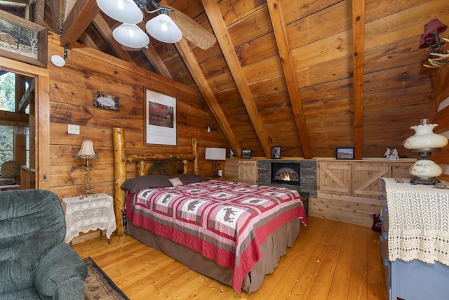 bedroom with lofted ceiling with beams, wooden ceiling, wooden walls, and light hardwood / wood-style floors