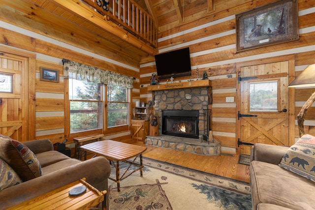 living room with a stone fireplace, wood walls, and hardwood / wood-style flooring