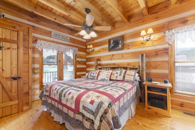 bedroom featuring beam ceiling, ceiling fan, wood walls, wood ceiling, and light wood-type flooring