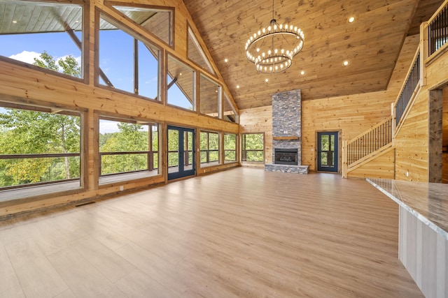 unfurnished living room with wooden ceiling, a fireplace, high vaulted ceiling, and a chandelier