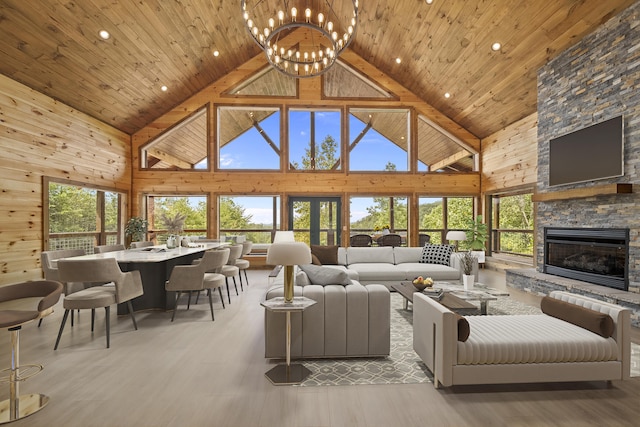 living room featuring a fireplace, an inviting chandelier, high vaulted ceiling, and wood ceiling