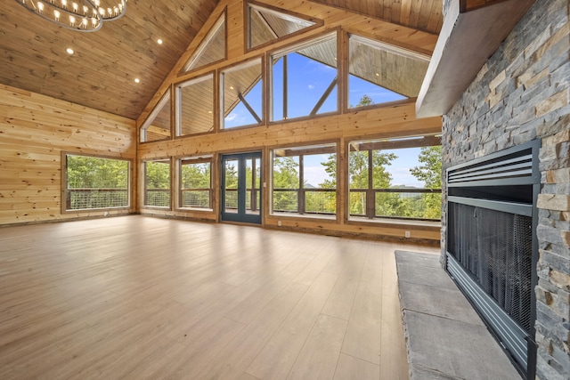 unfurnished living room with high vaulted ceiling, a notable chandelier, wood-type flooring, a fireplace, and wood ceiling