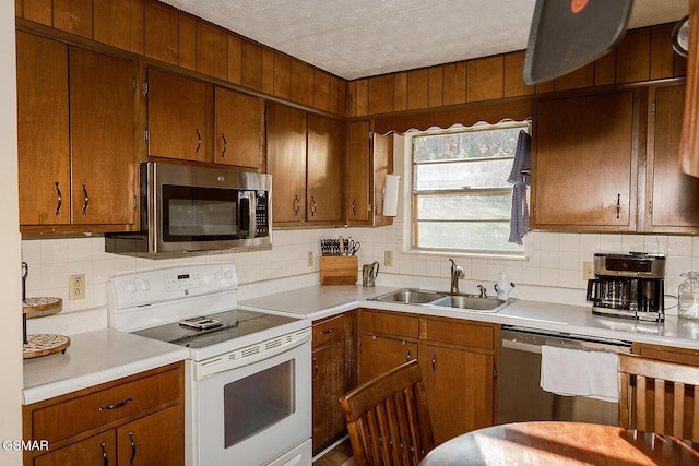 kitchen featuring tasteful backsplash, sink, stainless steel appliances, and a textured ceiling