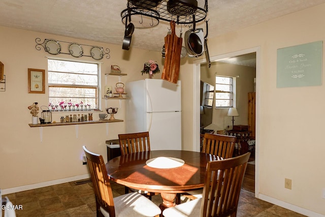 dining area featuring a healthy amount of sunlight and a textured ceiling