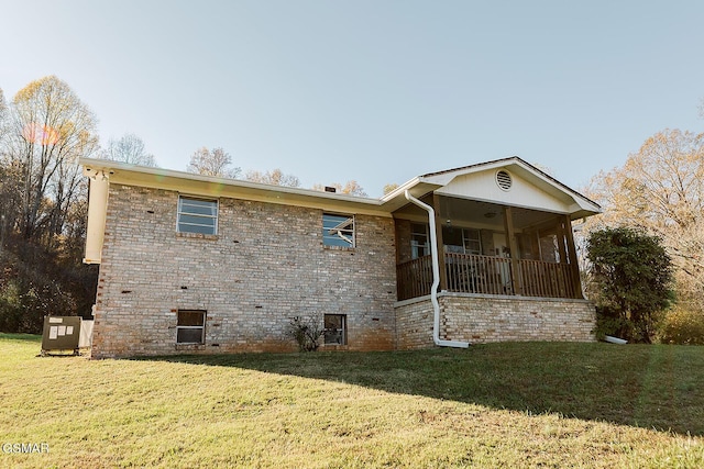 back of property with a sunroom and a yard