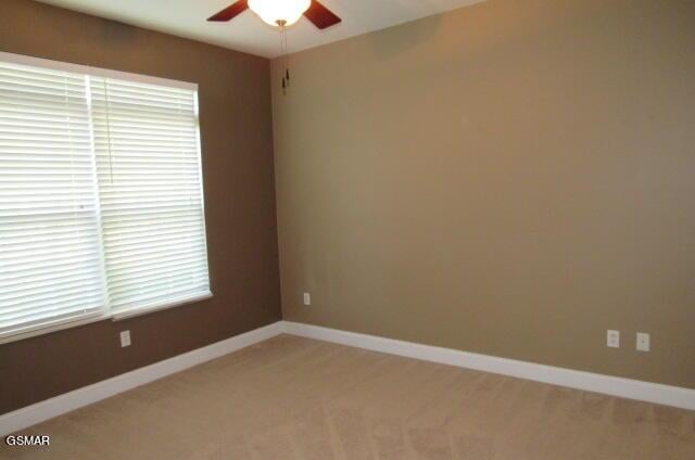 carpeted empty room featuring ceiling fan