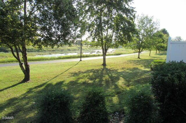 view of property's community featuring a water view and a lawn