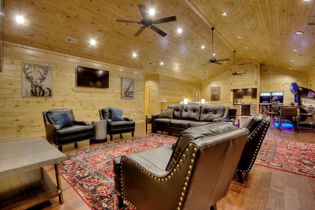 home theater room with hardwood / wood-style floors, lofted ceiling, wooden ceiling, wooden walls, and ceiling fan