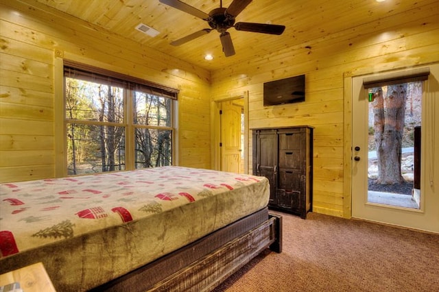 carpeted bedroom featuring ceiling fan, wooden ceiling, and wood walls