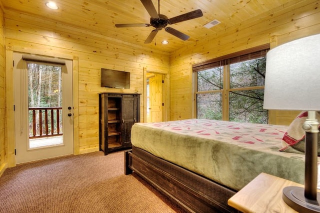 bedroom featuring ceiling fan, access to outside, wooden walls, and multiple windows
