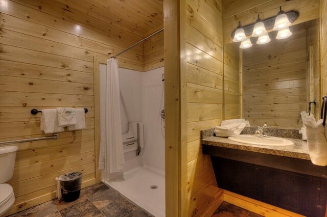 bathroom with walk in shower, vanity, wooden walls, wooden ceiling, and toilet