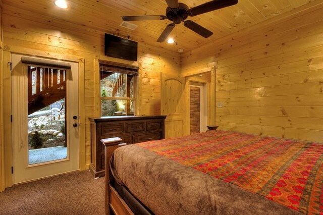 carpeted bedroom with ceiling fan, wood walls, and wooden ceiling