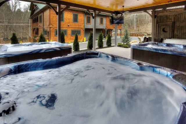 view of swimming pool featuring ceiling fan and a hot tub