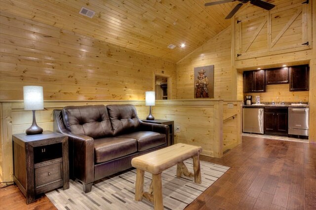 living room with light wood-type flooring, wood ceiling, ceiling fan, high vaulted ceiling, and wood walls